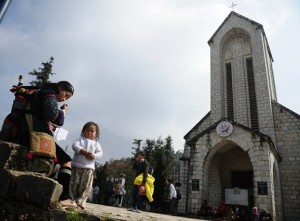 A Hmong woman sells souvenirs in front of a church in Sapa in Vietnam's northern highlands. AFP PHOTO
