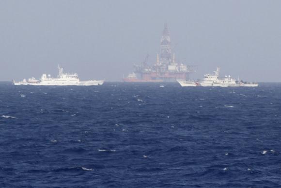Chinese oil rig Haiyang Shi You 981 (C) is seen surrounded by ships of China Coast Guard in the South China Sea, about 210 km (130 miles) off shore of Vietnam May 14, 2014. CREDIT: REUTERS/NGUYEN HA MINH