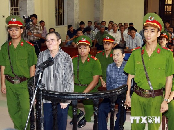 Bị cáo Trần Văn Miên (đứng thứ 2 bên trái) và Trần Văn Sang (phía sau) trước vành móng ngựa. (Ảnh: Doãn Tấn/TTXVN)