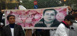Supporters hold up a banner reading “Free Le Quoc Quan” outside Hanoi People’s Court