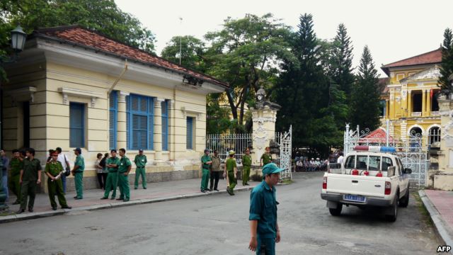 Policemen and security staff stand outside the main entrance gate of Ho Chi Minh City's People's Court where three bloggers stand trial for 'anti-state propaganda,' September 2012.