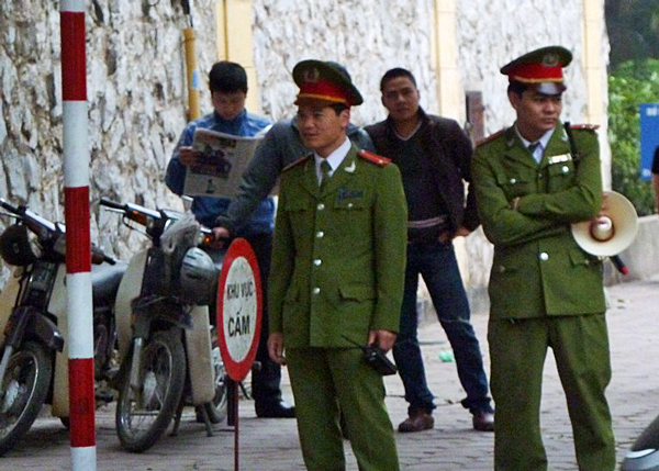 Police in uniforms and plainclothes patrol the area outside the courthouse in Hanoi, April 4, 2011.