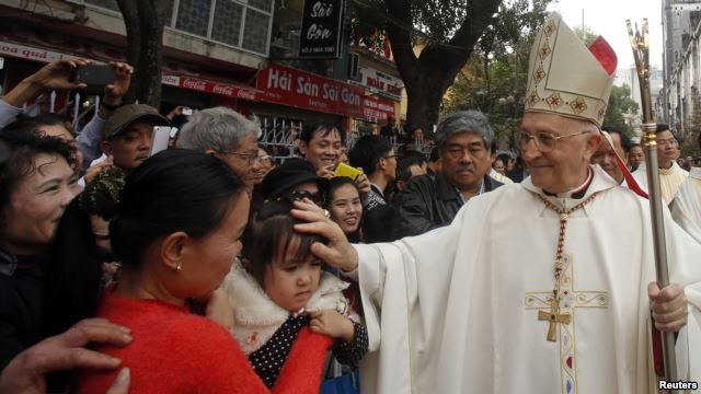 Đức Hồng Y Fernando Filoni (phải) ban phước cho một em bé trước Nhà thờ St. Joseph ở Hà Nội, ngày 20/1/2015.