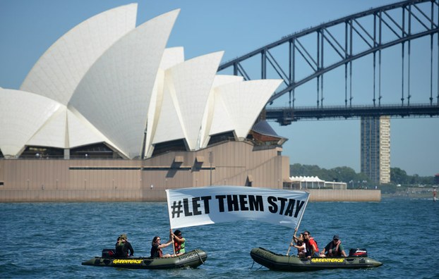 Members of the environmental group Greenpeace hold up a sign that reads "#LET THEM STAY" in a protest over Australia's refugee policies, Feb. 14, 2016.