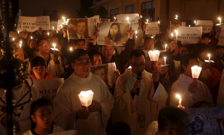 Catholics hold candles and placards with the image of Nguyen Van Dai and his assistant Le Thu Ha during a mass prayer for Dai and Ha at Thai Ha church in Hanoi, December last year. Rights activist Nguyen Van Dai, who was badly beaten by unknown attackers, was arrested for anti-state "propaganda" in what rights groups fear is a crackdown on government critics.